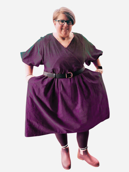 Person wearing a red dress standing on a wooden deck with a playground in the background
