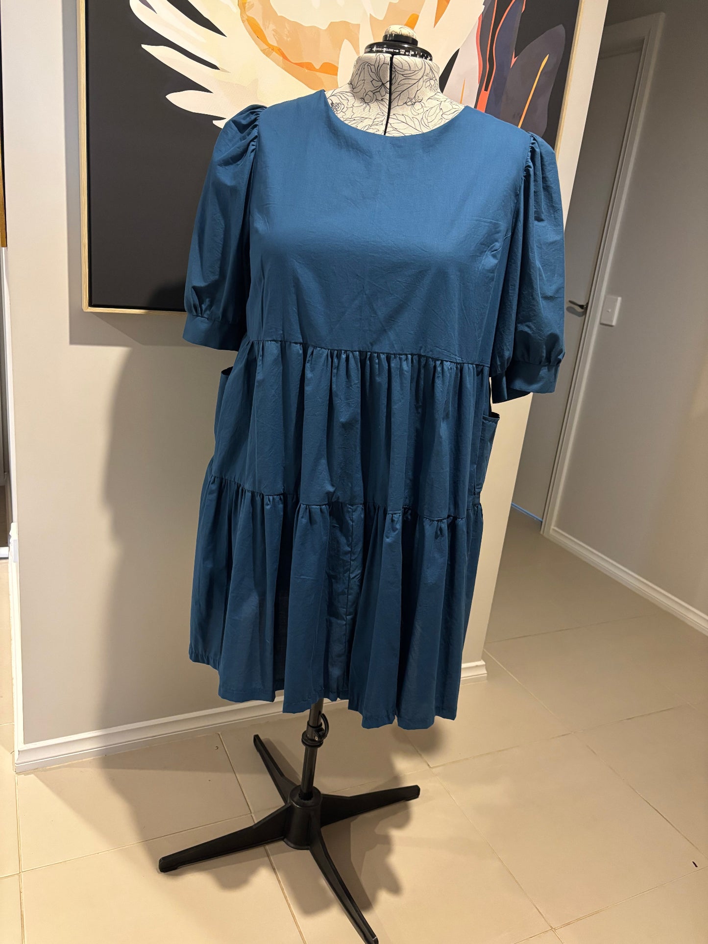 Blue dress on a mannequin against a neutral background